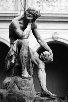 black and white photograph of a statue of a man holding a ball in his hands