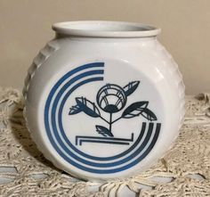 a white and blue vase sitting on top of a doily