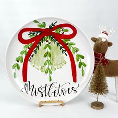 a white plate with a red bow on it and a reindeer figurine next to it