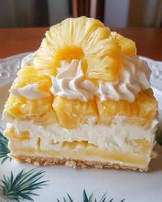 a piece of cake with pineapple and whipped cream on top sits on a plate