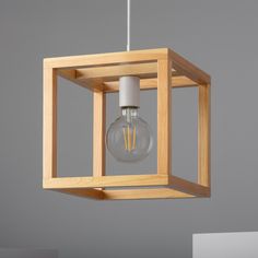 a light that is inside of a wooden box hanging from a ceiling fixture in a room