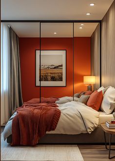 a bedroom with an orange accent wall and white bedding, along with a painting on the wall