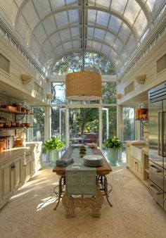 a kitchen with an island in the middle and lots of windows on the ceiling above it