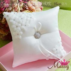 a white pillow on a pink tray with flowers in the background