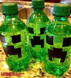 three green water bottles with the faces of minecraft on them sitting on a counter