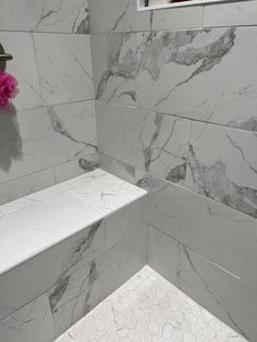 a bathroom with white marble walls and floor