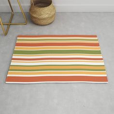 an orange, green, yellow and white striped rug next to a basket on the floor