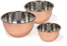 three metal bowls with holes in them on a white background, one is pink and the other is silver