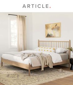 a bed sitting on top of a wooden floor next to a window