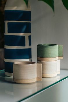 two vases sitting next to each other on a shelf