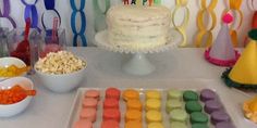 a birthday cake with candles on it and candy in bowls next to the cake,