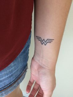 a woman's arm with a small tattoo on the left side of her wrist