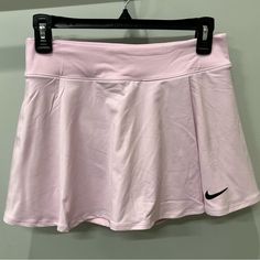 a pink nike skirt hanging on a hanger