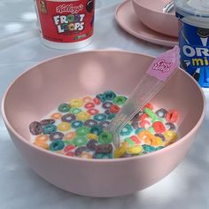 a pink bowl filled with cereal sitting on top of a table