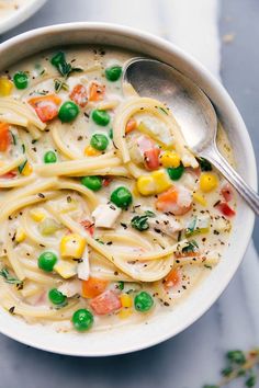 a white bowl filled with pasta and veggies