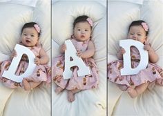 a baby laying on top of a bed holding a white letter that says d is for d