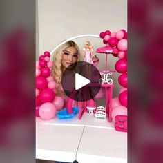 a barbie doll sitting in front of a table with pink balloons and decorations on it