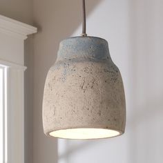 a light that is hanging from a ceiling in a room with white walls and windows