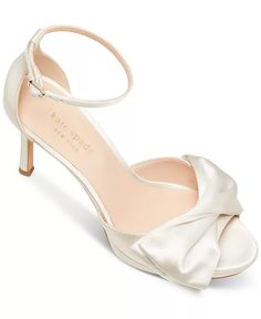 a woman's white shoe with a bow on the toe and heels in satin