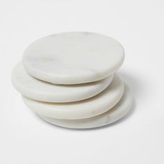 four white coasters stacked on top of each other