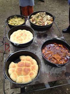 four pans filled with food sitting on top of a table