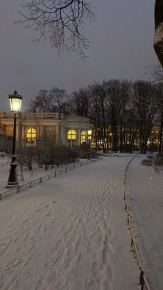 a street light in the middle of a snow covered park