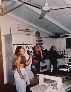 three women standing in a kitchen talking to each other