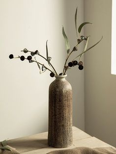 a vase with some flowers in it on a table next to a window sill