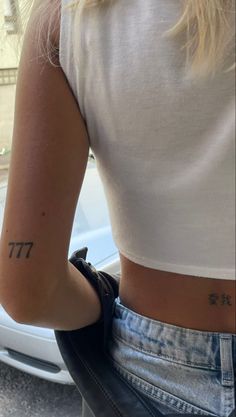 a woman with a small tattoo on her left arm and the word tt tattooed on her right arm