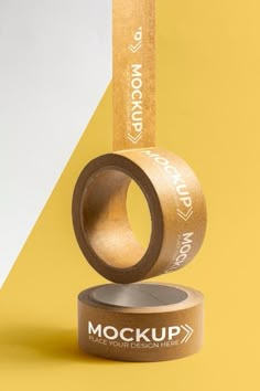 a roll of brown tape sitting on top of a yellow and white background with the word mockup printed on it