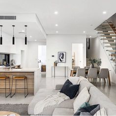 a living room filled with furniture next to a kitchen