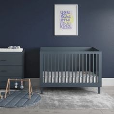 a baby's room with a crib, dresser and bed in grey tones