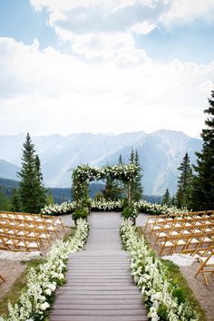 an outdoor ceremony setup with white flowers and greenery