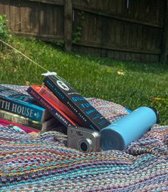 some books and a camera on a blanket