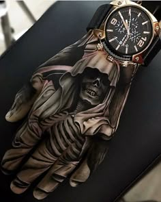 a glove with a skeleton on it sitting on top of a chair next to a watch