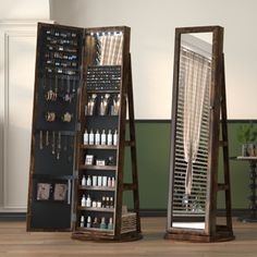 two tall wooden mirrors sitting next to each other on top of a hard wood floor