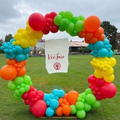 a bunch of balloons in the shape of a wreath on grass with a sign that says ketchup