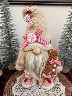 a stuffed animal sitting on top of a table next to a christmas hat and two gingerbreads