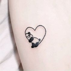 a panda bear with a heart tattoo on the left side of the leg, it is black and white