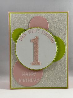 a birthday card with the number one in pink, green and silver on it's front