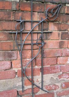 an iron sculpture on the side of a brick wall