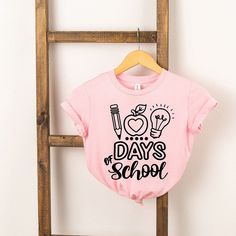 Looking for a cute tee for your kids? We have the perfect 100 Days Of School graphic tee addition to their closet! Also available in youth tees. Playful Funny Print T-shirt For School, Fun T-shirt With Funny Print For Back To School, Pink School Spirit T-shirt For Back To School, Fun T-shirt For Back To School, Cute Text Print Tops For School, Fun Pink T-shirt For End Of School Year, Cute Slogan Tops For School, Cute Letter Print T-shirt For End Of School Year, Cute Pre-shrunk T-shirt For School