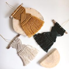 three tassels are sitting on a plate next to a piece of wood and yarn