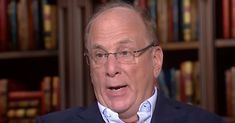 an older man wearing glasses and a suit is talking to someone in front of bookshelves