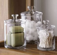 three glass containers filled with candles and marshmallows