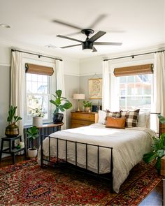 a bedroom with a bed, rug and ceiling fan