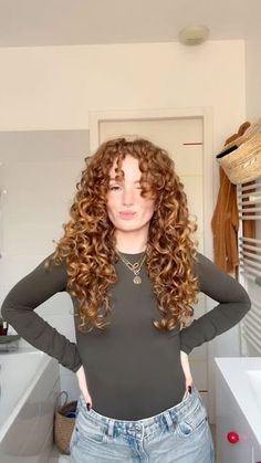 a woman standing in a bathroom with her hands on her hips