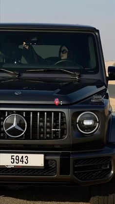 the front view of a black mercedes g - class