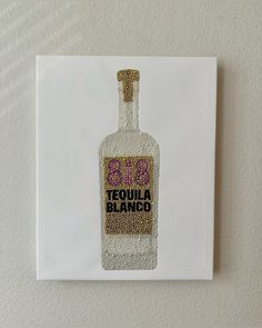 a bottle with the word tequila printed on it is mounted to a wall in front of a white background