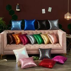 a pink couch with many different colored pillows on it